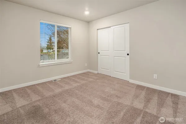 an empty room with windows and closet