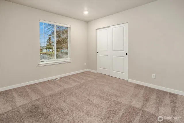 an empty room with windows and closet
