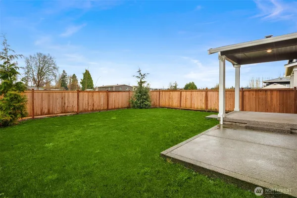 a view of a backyard with wooden fence