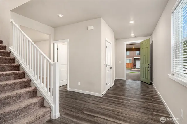 a view of a hallway with wooden floor and entryway