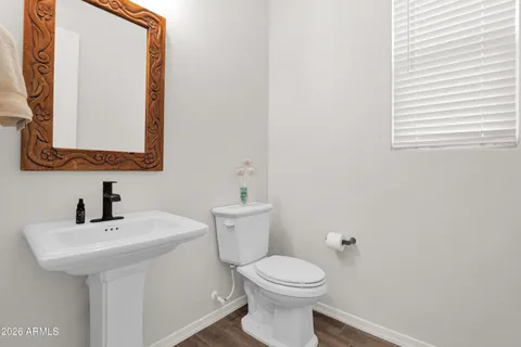 a bathroom with a toilet a sink a mirror and a window