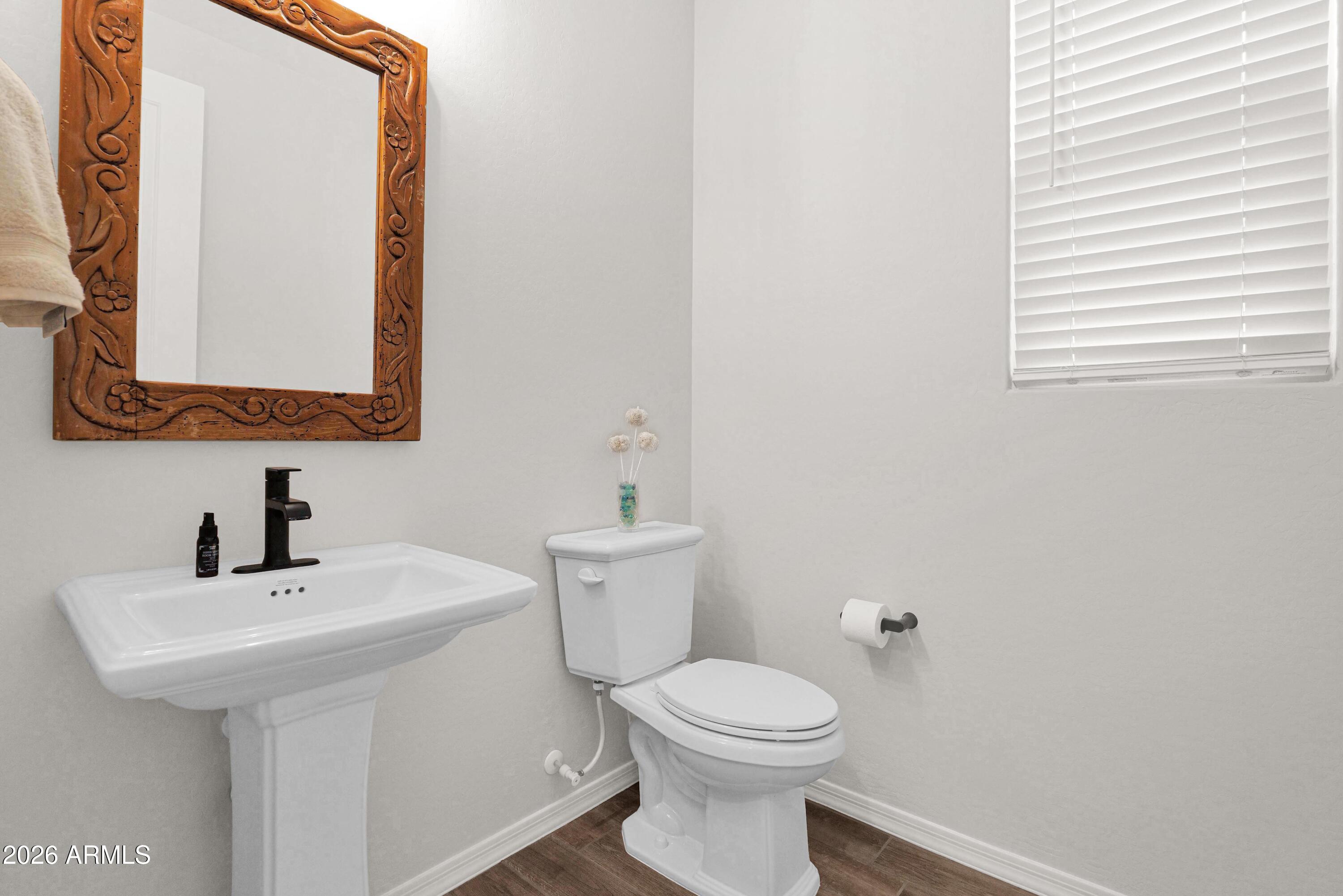 3461 West Oil Well Road San Tan Valley, AZ 85144 - Photo 18 of 25 a bathroom with a toilet a sink a mirror and a window