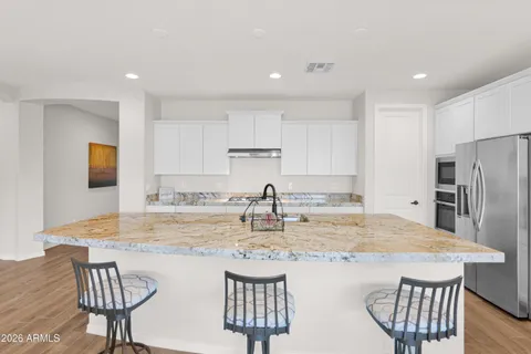 a kitchen with stainless steel appliances granite countertop a kitchen island a stove a table and chairs