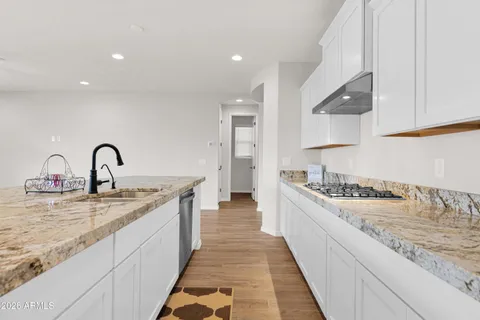 a large kitchen with stainless steel appliances granite countertop a lot of counter space and a sink