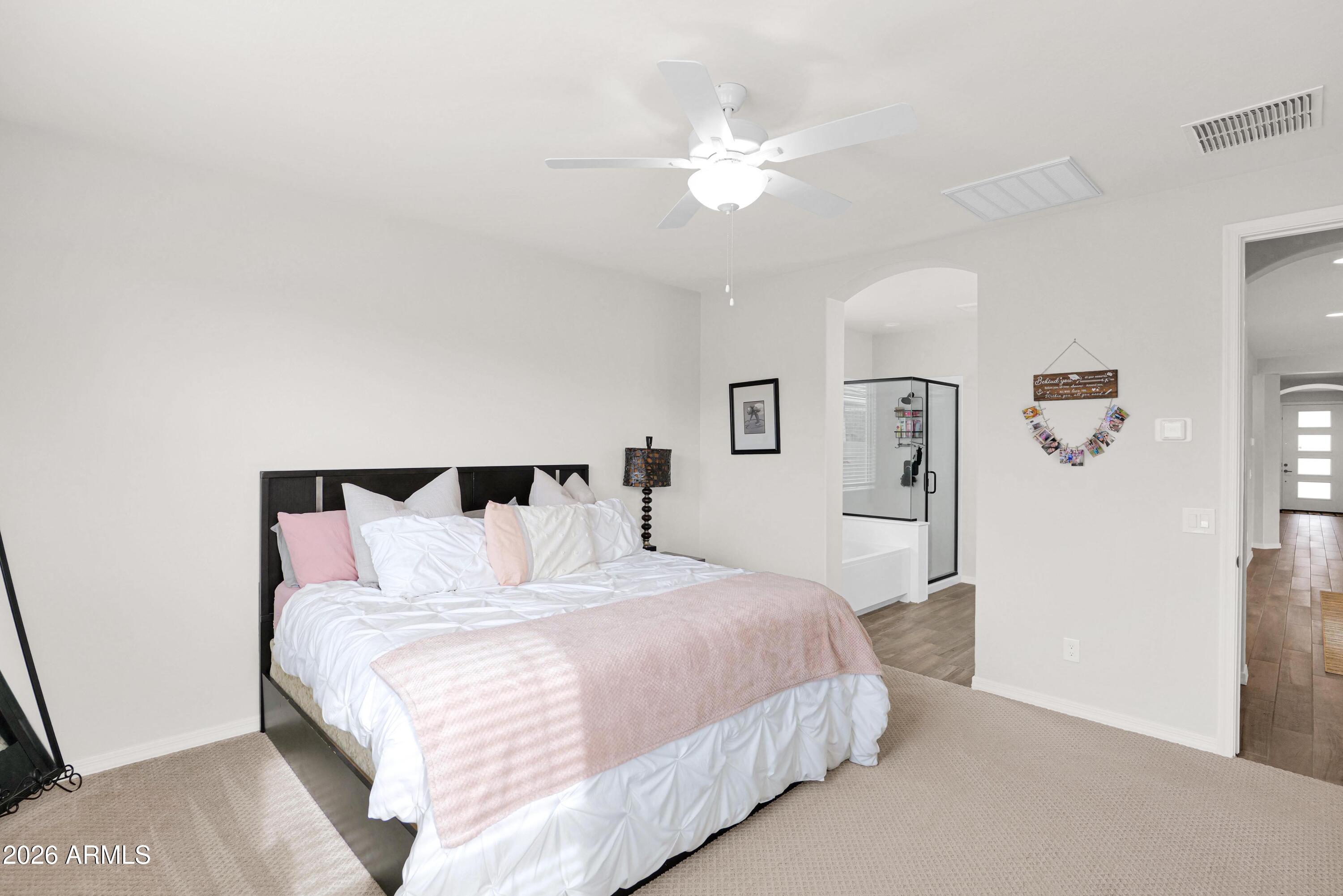 3461 West Oil Well Road San Tan Valley, AZ 85144 - Photo 9 of 19 a bedroom with a bed and a chandelier