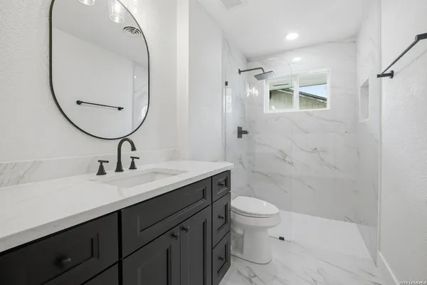 a bathroom with a sink a toilet and a mirror