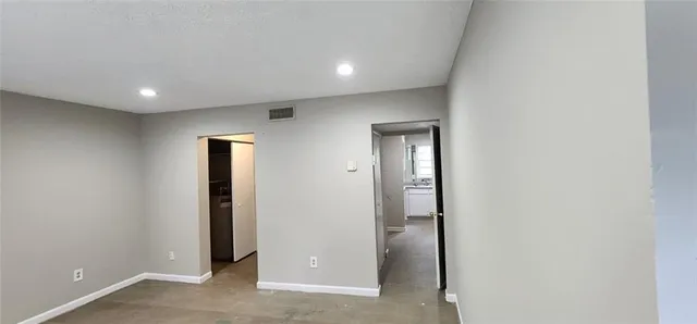 an empty room with mirror in hallway