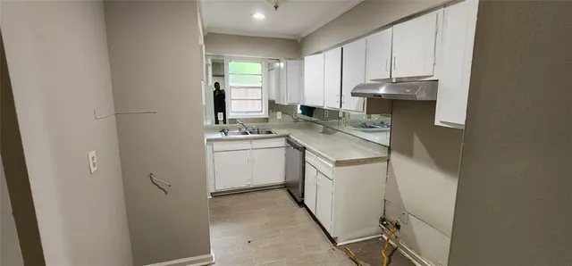 a kitchen with a sink a stove cabinets and a window