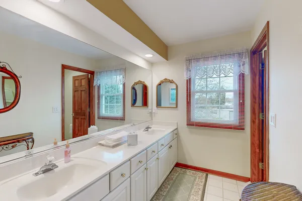 a spacious bathroom with a double vanity sink a mirror and a shower