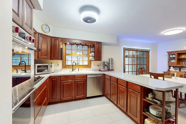 a large kitchen with stainless steel appliances granite countertop a sink and cabinets