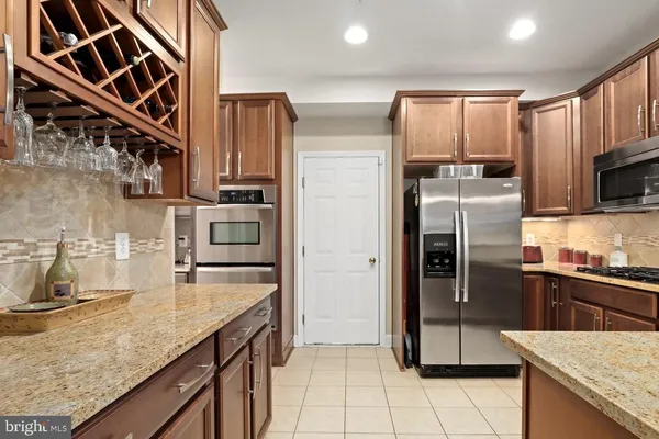 a kitchen with stainless steel appliances granite countertop a refrigerator a stove and a sink