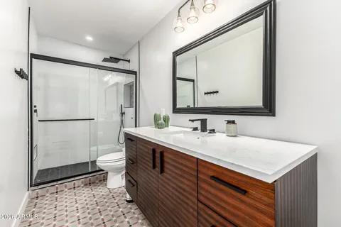 a bathroom with a sink a toilet and a mirror