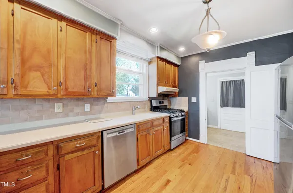 a kitchen with stainless steel appliances granite countertop a sink a stove and a refrigerator