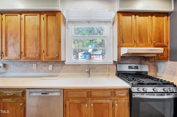 a kitchen with a stove a sink and a counter space