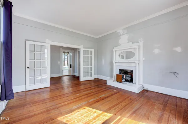 a view of empty room with wooden floor and fireplace