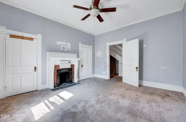 a view of a livingroom with a fireplace and ceiling fan