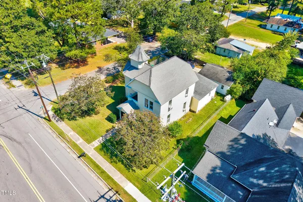 a aerial view of a house with swimming pool and large trees