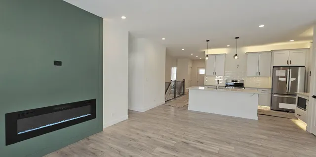 a view of kitchen with kitchen island white cabinetry and refrigerator