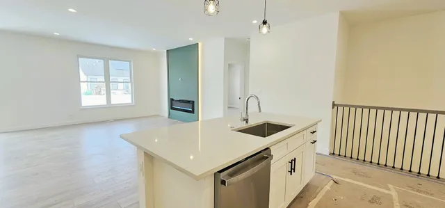 a kitchen with stainless steel appliances granite countertop a sink and dishwasher with wooden floor