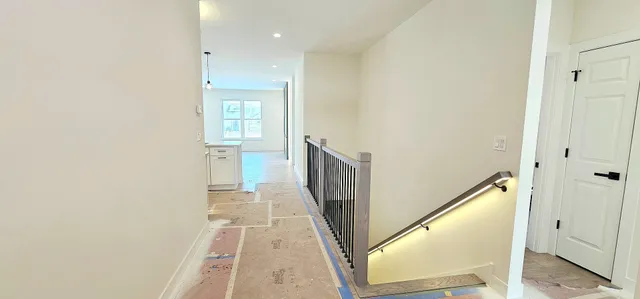 a view of a hallway with wooden floor and staircase