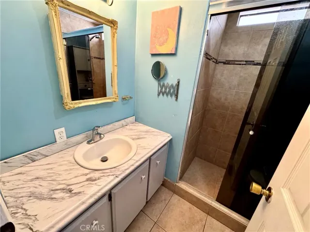 a bathroom with a sink and mirror with bathtub