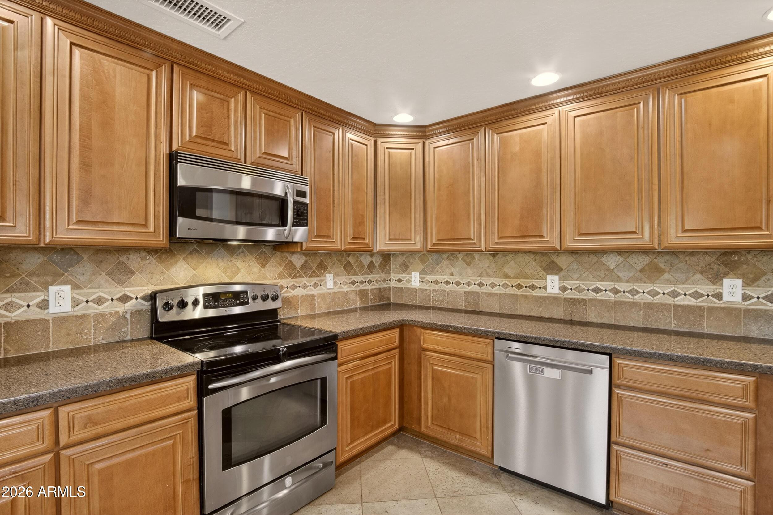 21320 North 56th Street, Unit 2125 Phoenix, AZ 85054 - Photo 18 of 39 a kitchen with stainless steel appliances granite countertop white cabinets granite counter tops and a window