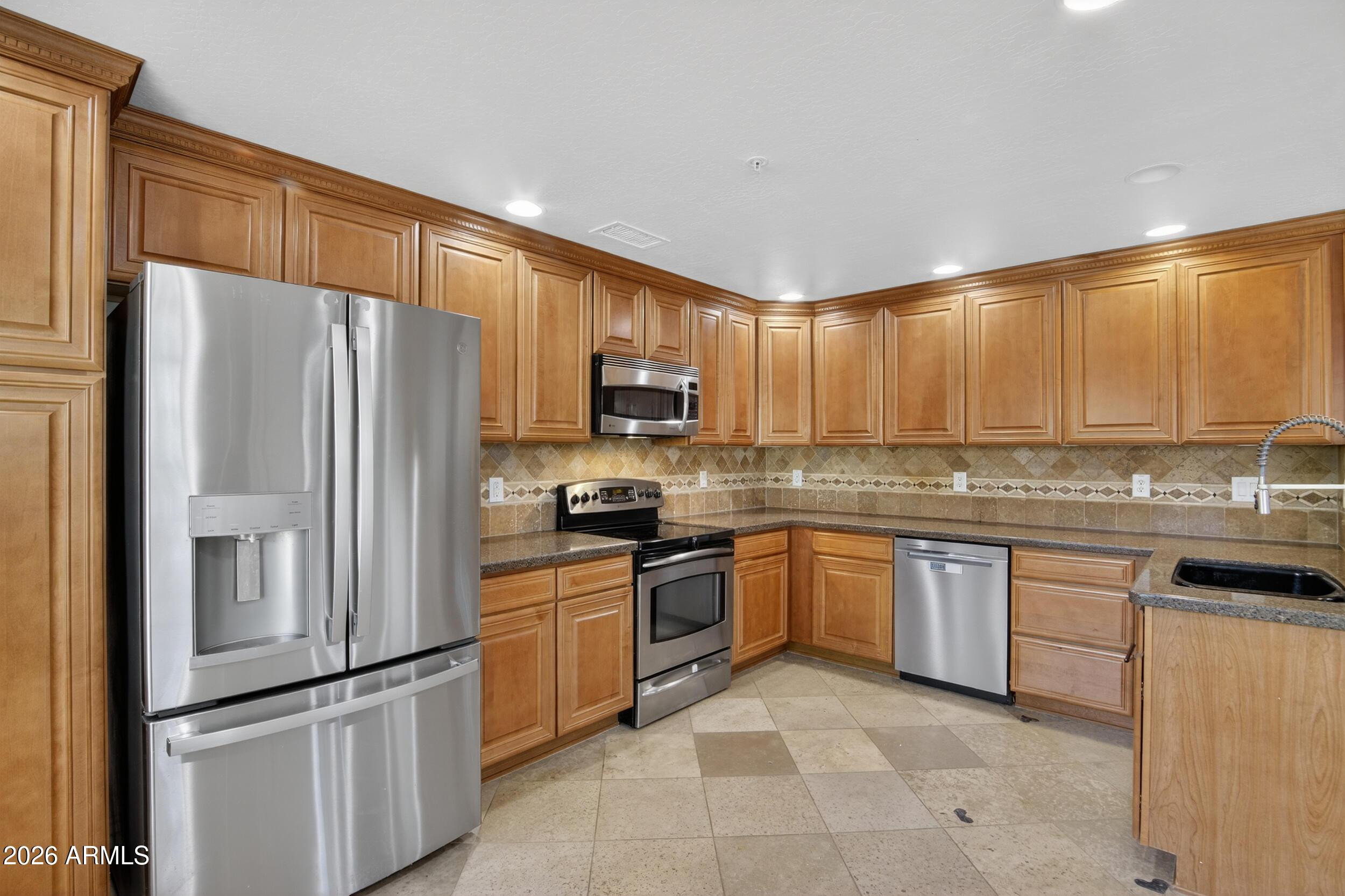 21320 North 56th Street, Unit 2125 Phoenix, AZ 85054 - Photo 19 of 39 a kitchen with granite countertop stainless steel appliances a refrigerator sink and microwave