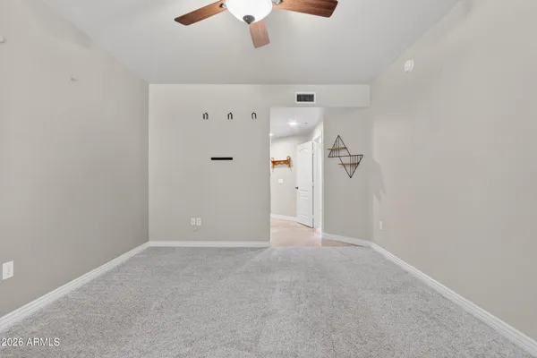 an empty room with fan and entrance
