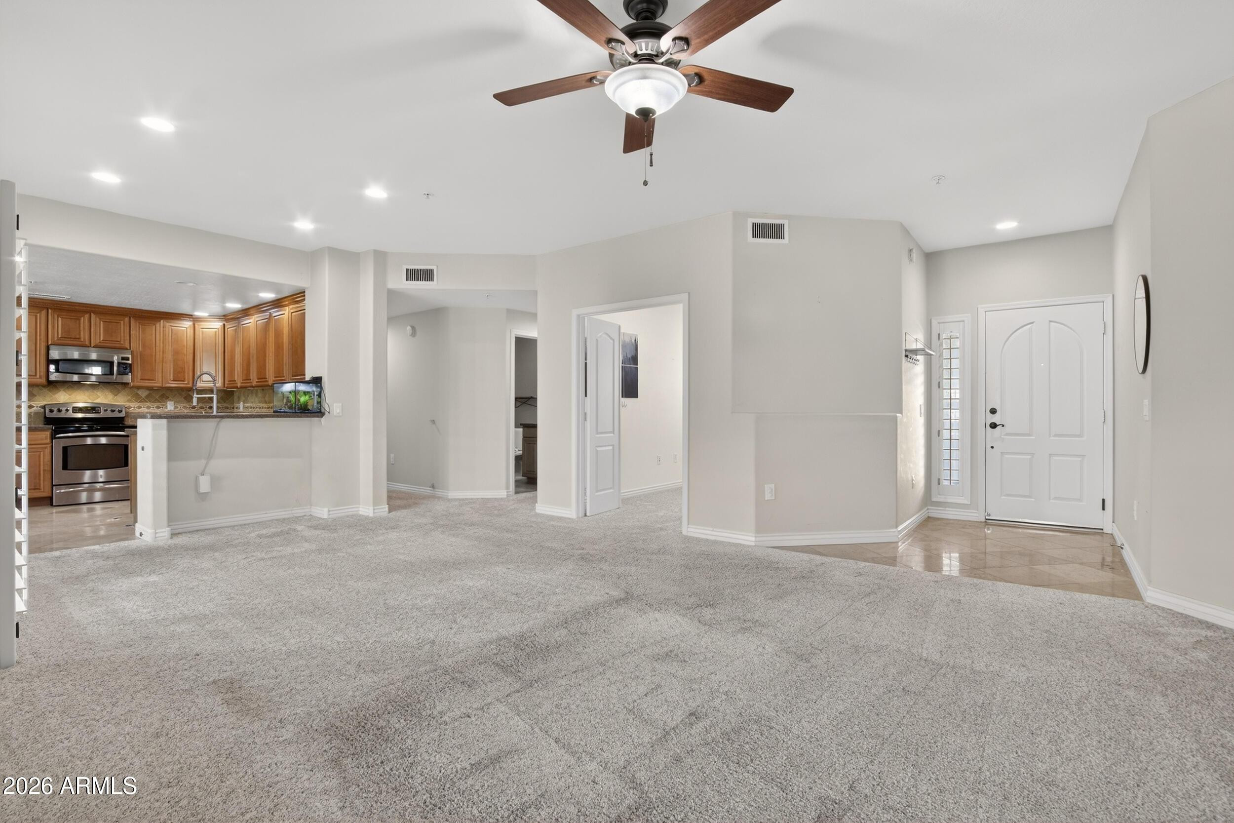 21320 North 56th Street, Unit 2125 Phoenix, AZ 85054 - Photo 7 of 39 a view of a livingroom with a kitchen space stainless steel appliances and a chandelier