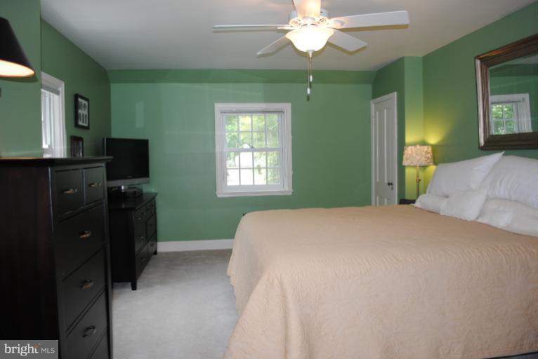 5803 Kenmore Road Baltimore, MD 21210 - Photo 22 of 29 a bedroom with a bed and a chandelier