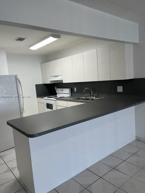 961 West 44th Street Hialeah, FL 33012 - Photo 19 of 35 a kitchen with stainless steel appliances granite countertop a sink a stove and a refrigerator