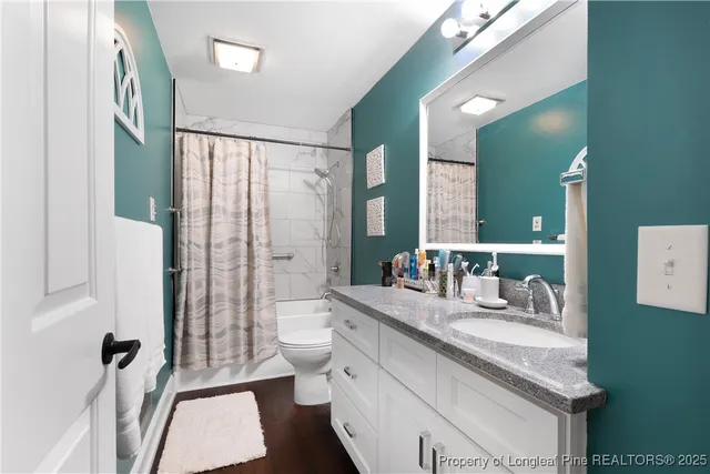 a bathroom with a granite countertop sink toilet and shower
