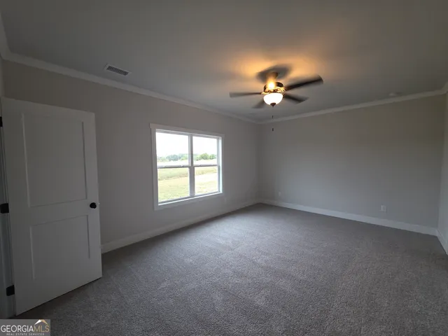 an empty room with a ceiling fan and window