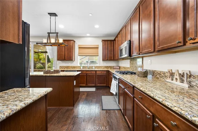 a kitchen with kitchen island granite countertop wooden cabinets and a sink