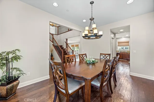 a dining room with furniture potted plants and wooden floor