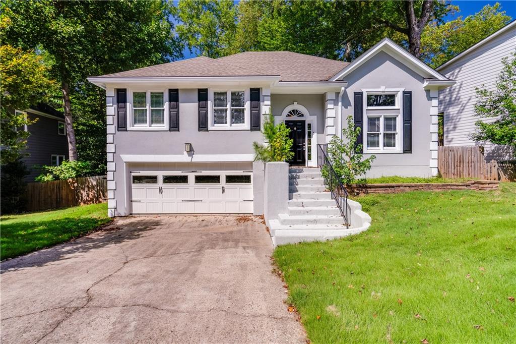 a front view of a house with a yard and potted plants
