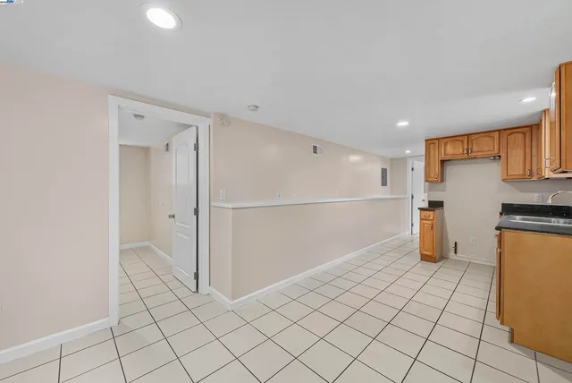 a large kitchen with granite countertop a sink and cabinets