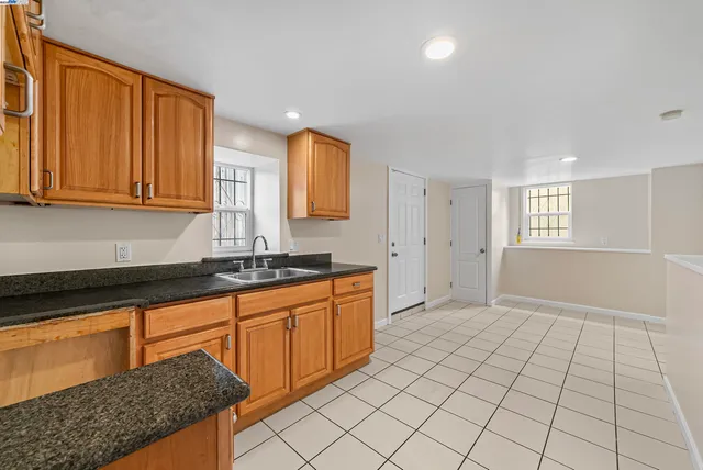 a bathroom with a granite countertop sink and a mirror