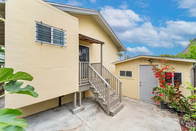 a view of a house with wooden walls and flower plants