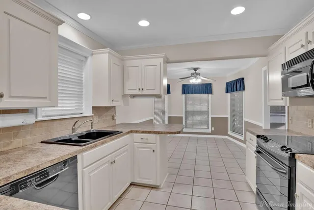 a kitchen with granite countertop a sink stove and cabinets