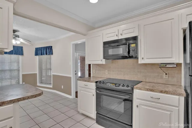 a kitchen with granite countertop white cabinets and stainless steel appliances