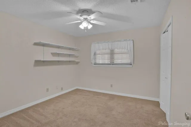 an empty room with a chandelier fan