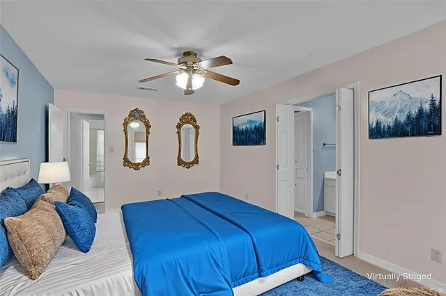 a bedroom with a large bed and ceiling fan