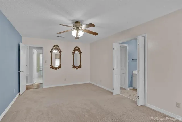 a view of an empty room with a chandelier fan