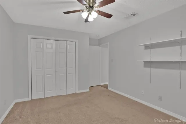 a view of an empty room and a ceiling fan
