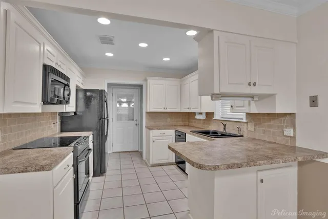 a kitchen with a sink a stove and cabinets