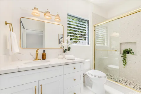 a bathroom with a sink a toilet and shower