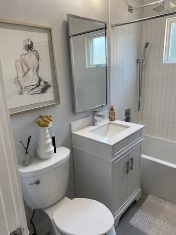 a bathroom with a sink mirror vanity and toilet