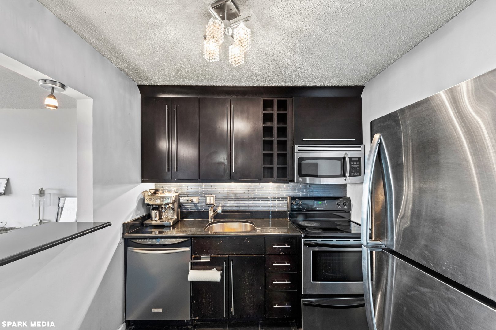 111 West Maple Street, Unit 1009 Chicago, IL 60610 - Photo 6 of 18 a kitchen with granite countertop a refrigerator and a stove