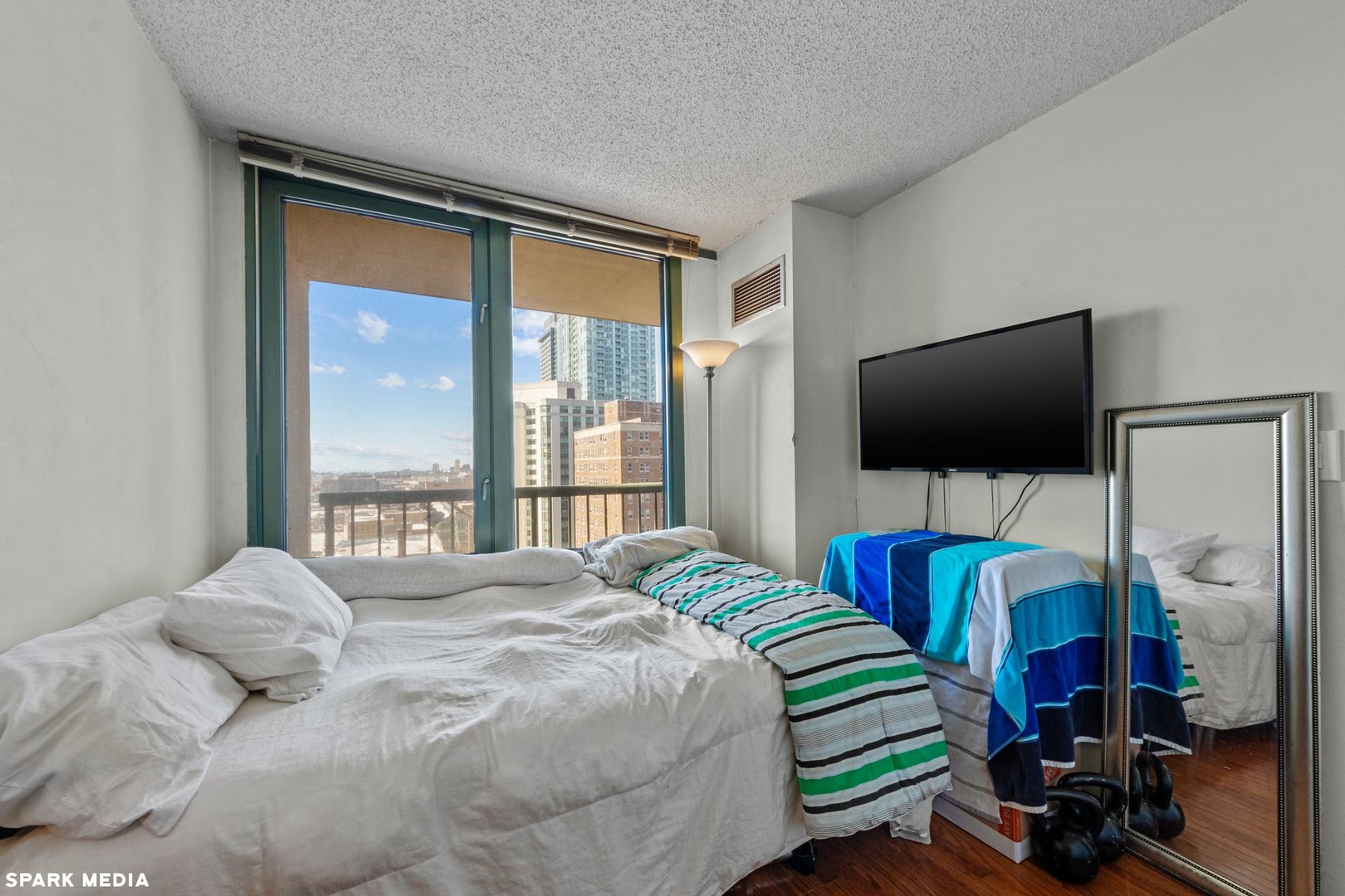 111 West Maple Street, Unit 1009 Chicago, IL 60610 - Photo 9 of 18 a bedroom with a bed and a flat screen tv